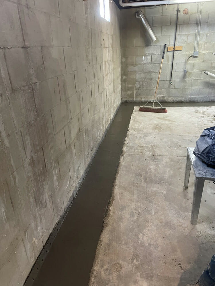 concrete restoration after footer drain tile is installed in order to waterproof this cinderblock wall foundation